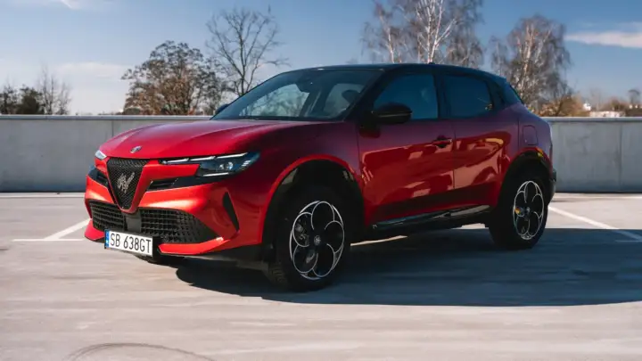 Czerwony Alfa Romeo Tonale na parkingu. Czy to superauto? Opinie są podzielone, ale wygląd robi wrażenie.