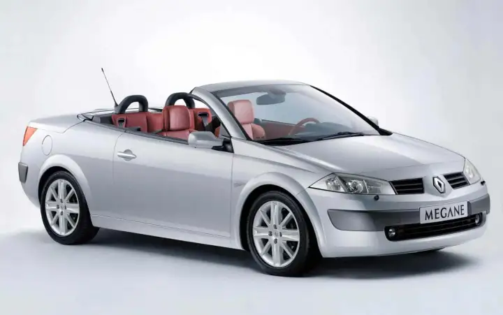 Srebrny Renault Megane cabrio z czerwonymi skórzanymi siedzeniami, gotowy na letnią przejażdżkę.