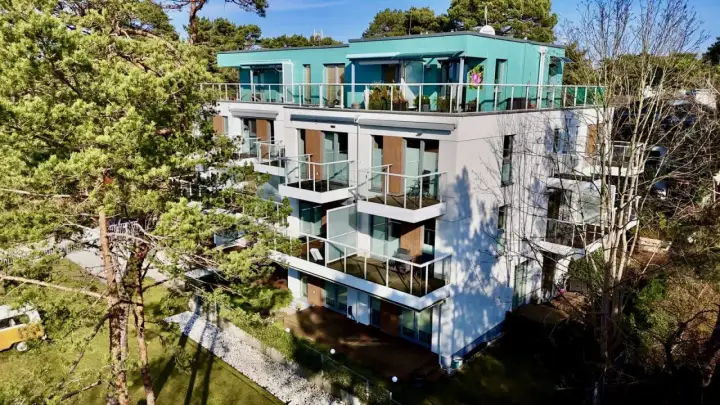 Nowoczesne władysławowo apartamenty przy plaży z widokiem na morze. Balkony z przeszklonymi balustradami i zielone otoczenie.