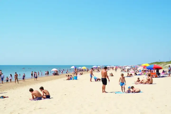 Tłum ludzi na plaży, idealne miejsce na wakacje. Gdzie najbliżej nad morze z Warszawy? Tutaj!