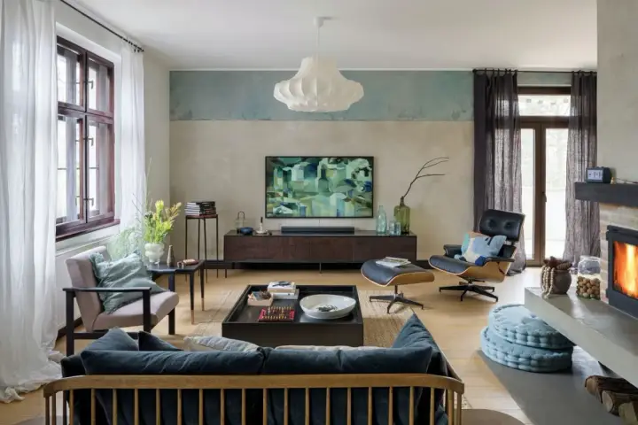 Nowoczesny salon z wygodną kanapą i fotelem. Abstrakcyjny obraz na ścianie dodaje charakteru.