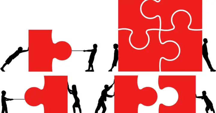 Dzieci i młodzież z generacji Z łączą czerwone elementy układanki, symbolizując współpracę i budowanie przyszłości.