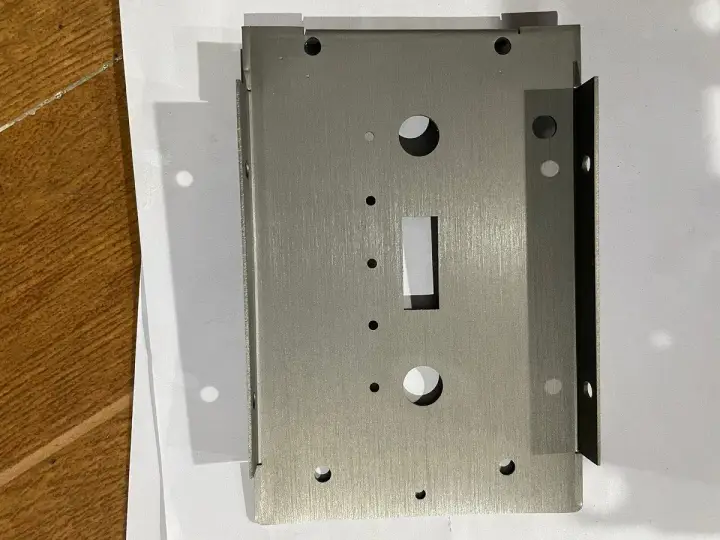 Plaque métallique en acier inoxydable 304l, avec des trous et une découpe rectangulaire, prête pour l'assemblage.