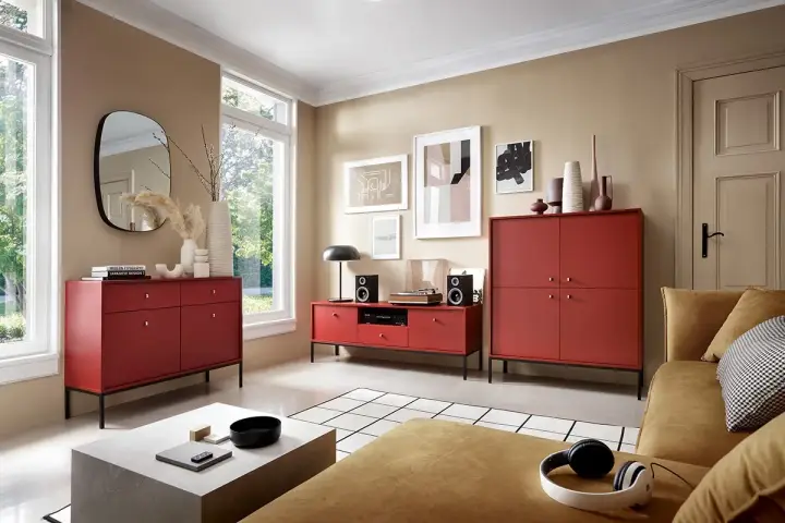 Nowoczesny salon z meblami w odcieniu burgundowym. Wygodna kanapa i stylowe komody tworzą przytulną atmosferę.