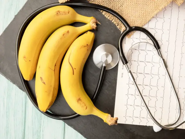 Trzy banany i stetoskop na tle EKG. Czy zastanawiałeś się, ile białka ma banan?