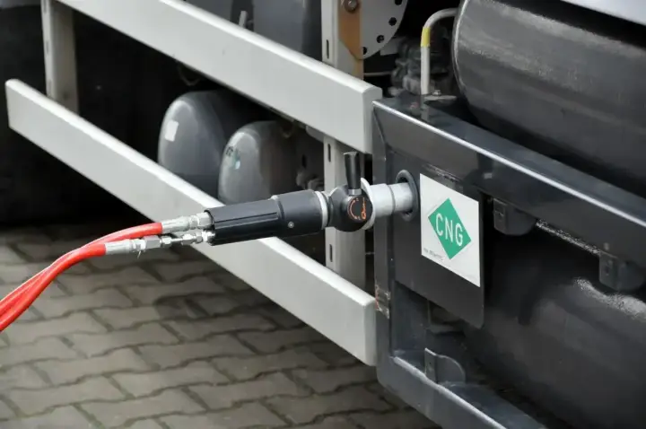 Tankowanie gazu CNG. Wąż podłączony do pojazdu z zielonym logo CNG. Gdzie tankować?