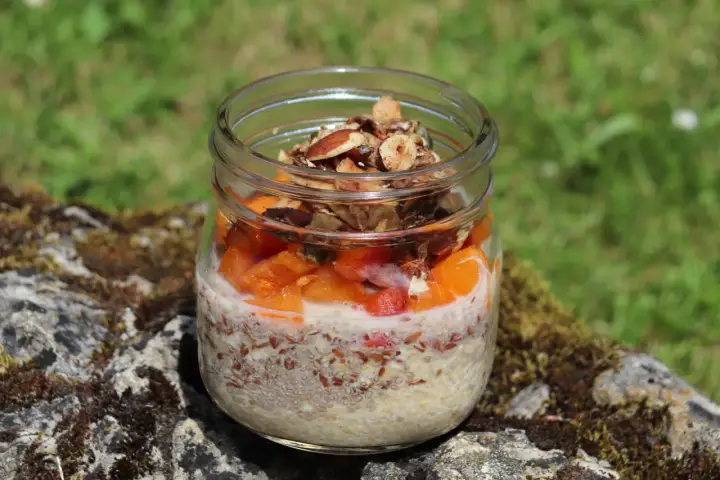 Veganes Overnight Oats im Glas mit Früchten und Nüssen, perfekt für einen gesunden Start in den Tag.