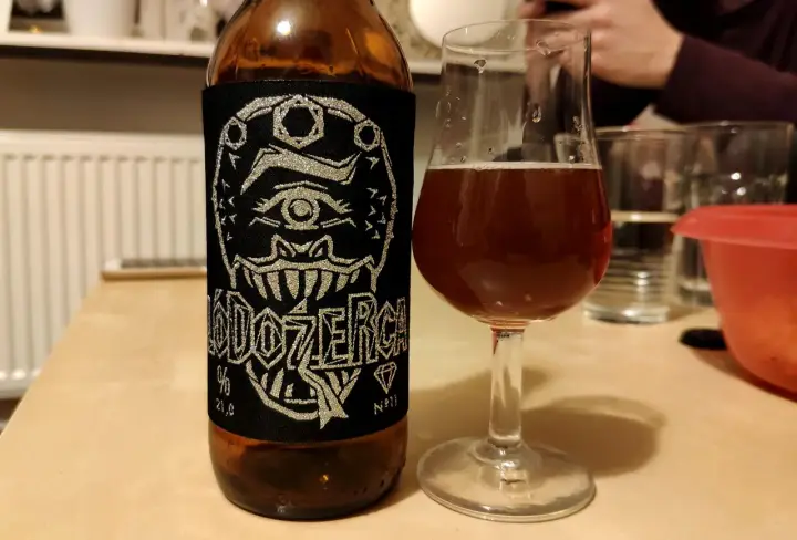 Butelka piwa z etykietą "DOZERGA" i kieliszek z bursztynowym trunkiem. Czy to najmocniejsze piwo w Polsce?