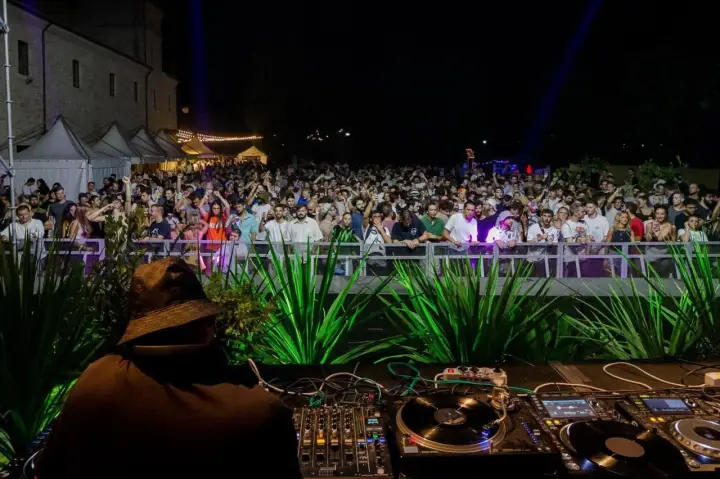 Un DJ suona per una folla entusiasta a uno dei tanti festival musicali in Italia.