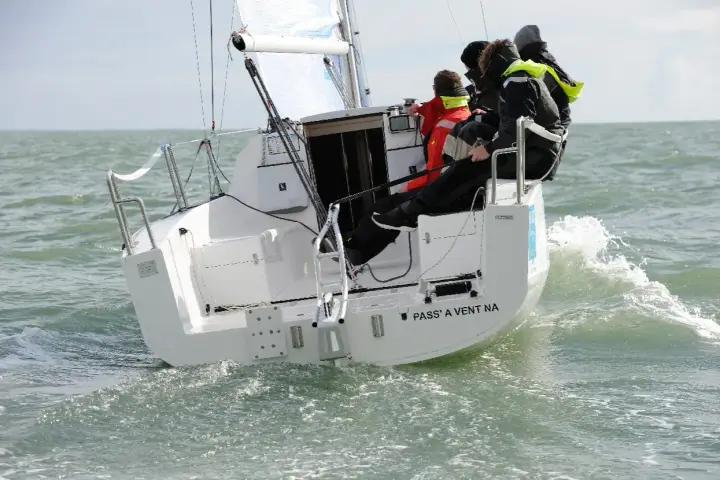 Équipage sur un voilier polonais transportable naviguant sur une mer agitée.