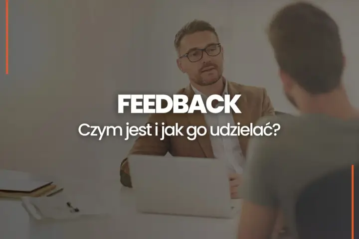 Dwóch mężczyzn przy biurku, jeden z nich udziela feedbacku. Czym jest feedback i jak go udzielać?