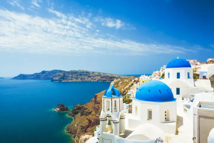 Santorini, Grecja. Białe domy z niebieskimi kopułami nad morzem. Sprawdź ceny wakacji!