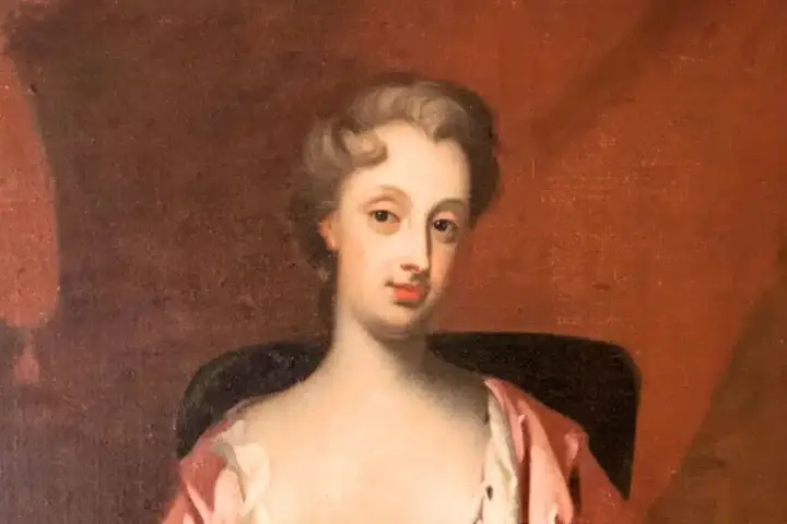 Porträtt av Christina Piper i rosa klänning, med en mjuk blick och uppsatt hår.