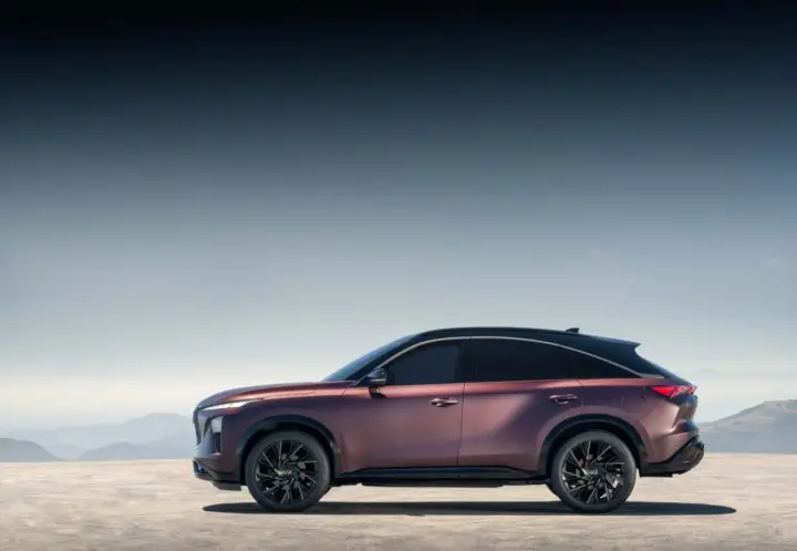 Eleganckie, bordowe infiniti auto z czarnym dachem na tle górskiego krajobrazu.