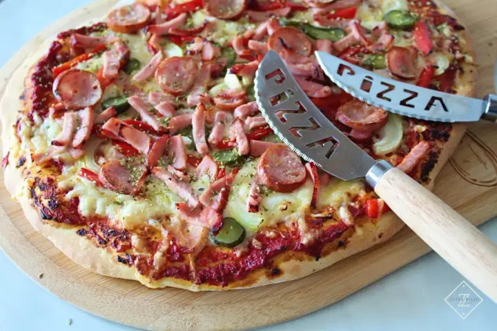 Pyszna pizza z kiełbasą i warzywami, gotowa do pokrojenia. To najlepsza pizza przepis, jaki kiedykolwiek próbowałeś!