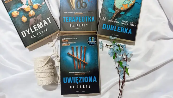 Książki B.A. Paris: "Dylemat", "Terapeutka", "Dublerka" i "Uwięziona" ułożone na białym tle.