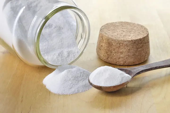 Bicarbonate de soude, une solution naturelle pour le traitement de l'oïdium. Une cuillère en bois et un pot renversé en témoignent.