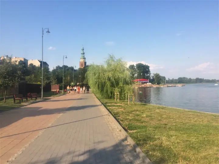 Spacer po chełmno trasa nad jeziorem. W oddali widać wieżę kościelną i zabudowania.