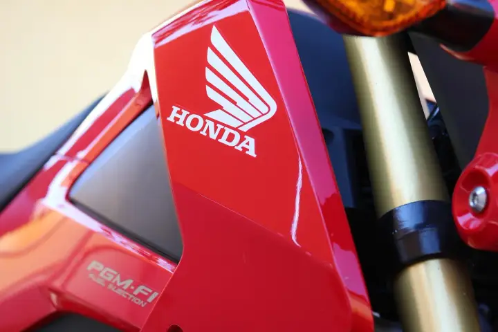 Czerwony motocykl Honda z logo i napisem PGM-FI. Pamiętaj o regularnych przeglądach motocykla 125!