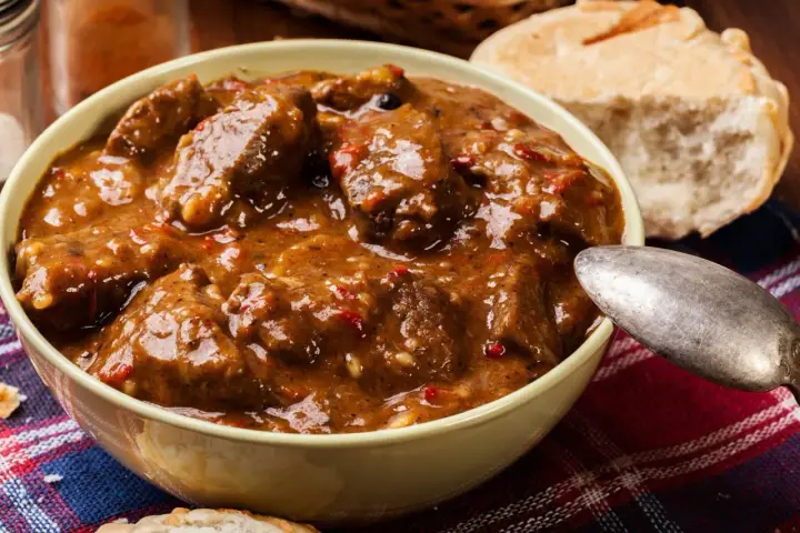 Un invitante stracotto toscano in una ciotola, pronto per essere gustato con pane fresco.