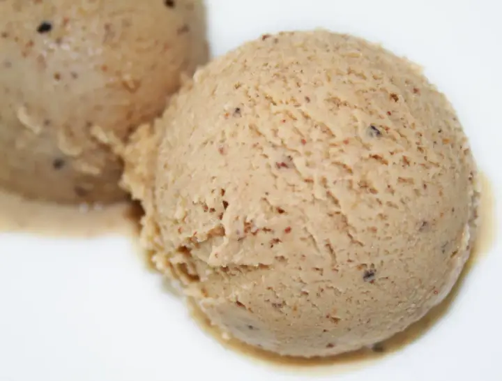 Deux boules de glace praliné, une recette gourmande et onctueuse, parsemée de petits éclats croquants.