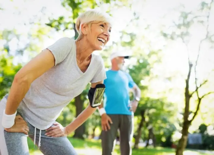 Glückliche Frau und Mann beim Joggen im Alter im Park. Sie genießen die Natur und die Bewegung.