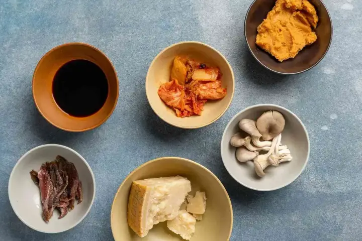 Składniki bogate w umami: sos sojowy, kimchi, miso, grzyby, parmezan i sardele.