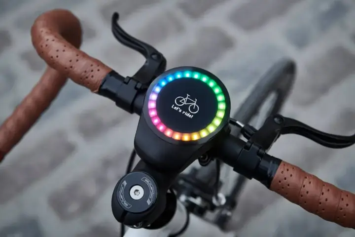 Nowy, okrągły wyświetlacz na kierownicy roweru z tęczowym podświetleniem i napisem "Let's ride!". Idealny do pomiaru prędkości, dystansu i innych parametrów, jak sigma rozmiar koła.