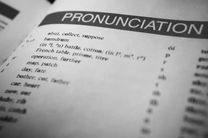 Otwarta książka z hasłem "PRONUNCIATION". Lista słów i symboli fonetycznych pokazuje, czy angielski jest trudny.