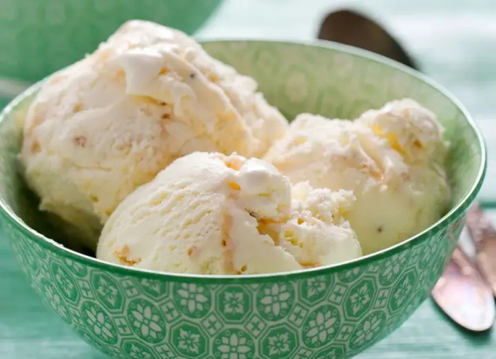 Kremowe lody z mascarpone w zielonej miseczce, idealne na upalny dzień.