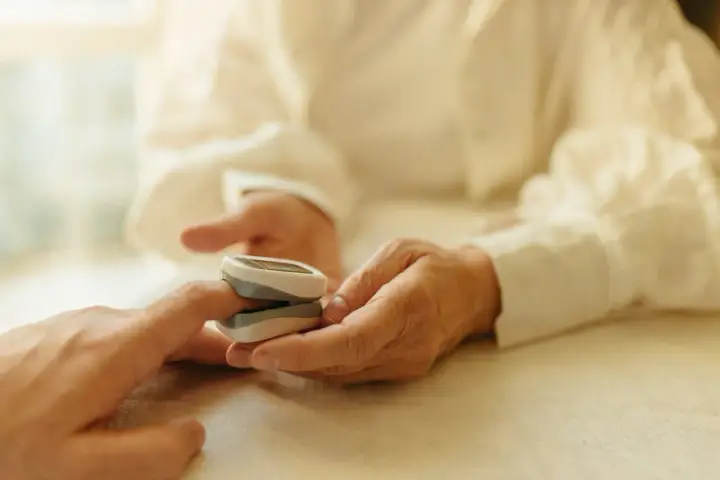 Puls 97 co oznacza? Na zdjęciu pulsoksymetr na palcu, wskazujący 97 uderzeń na minutę.