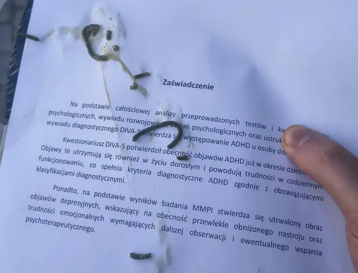 Na zaświadczeniu o ADHD, obok tekstu, widać ślady czegoś, co może przypominać trudności w pisaniu, jak przy dysgrafii.