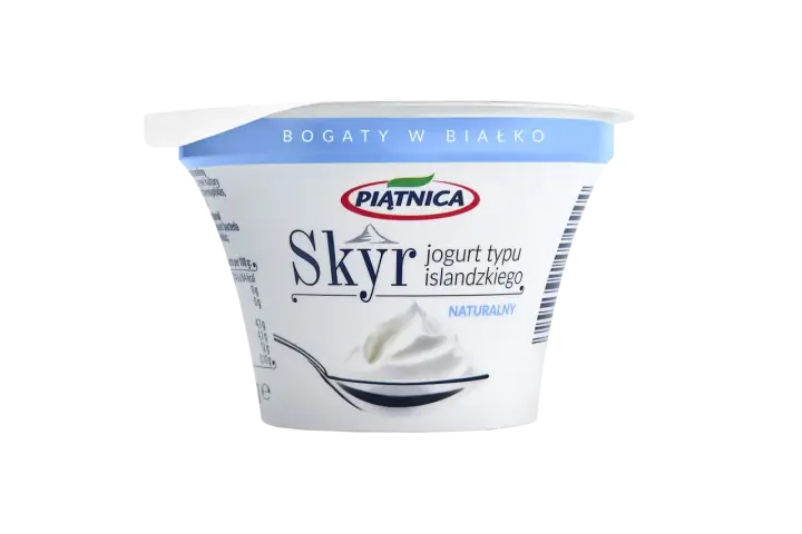 Opakowanie jogurtu typu islandzkiego Skyr Piątnica Naturalny z łyżką pełną jogurtu.
