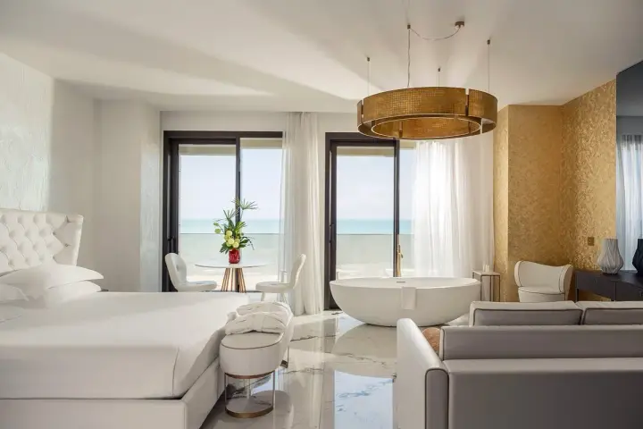Lussuosa camera con vista mare, perfetta per un soggiorno in un b&b Riviera Romagnola. Letto king, vasca freestanding e arredi eleganti.