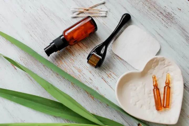 Zestaw do pielęgnacji: serum z **retinolem**, roller, ampułki i waciki.