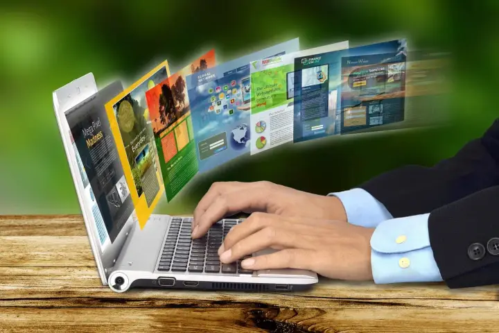 Dłonie piszą na laptopie, z którego wychodzą strony internetowe. To przykład, jak retoryka co to, czyli sztuka perswazji, działa w sieci.