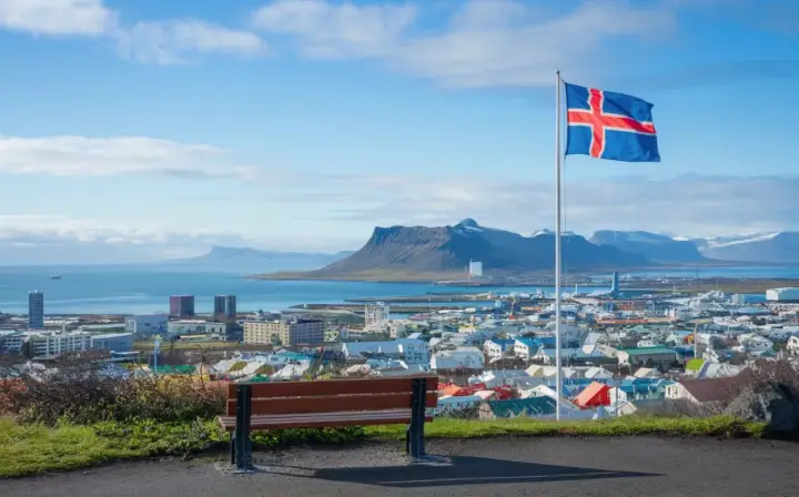 Widok na Reykjavík z flagą Islandii. Marzenie o pracy w Islandii staje się realne, patrząc na to miasto.