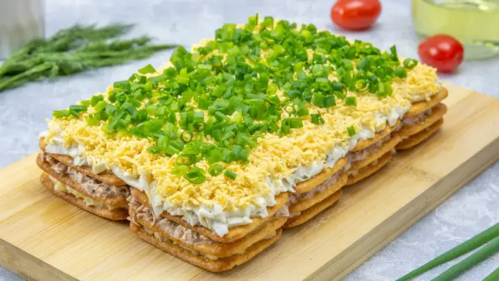 Warstwowa sałatka na krakersach z jajkiem, majonezem i szczypiorkiem. Pyszna przekąska na każdą okazję.