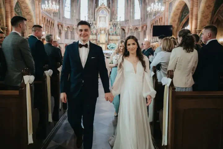 Para młoda idzie do ołtarza w kościele. To piękny ślub konkordatowy, pełen radości i miłości.