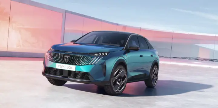 Nowy Peugeot E-3008 2021 w turkusowym kolorze, zaparkowany przed nowoczesnym budynkiem z różowymi akcentami.