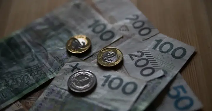 Polskie banknoty i monety. Czy umowa zlecenie wlicza się do emerytury? Pieniądze na stole.