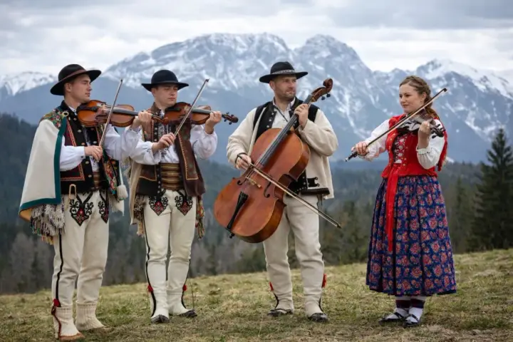 Muzykanci w strojach góralskich grają na instrumentach, prezentując żywą kulturę podhala.