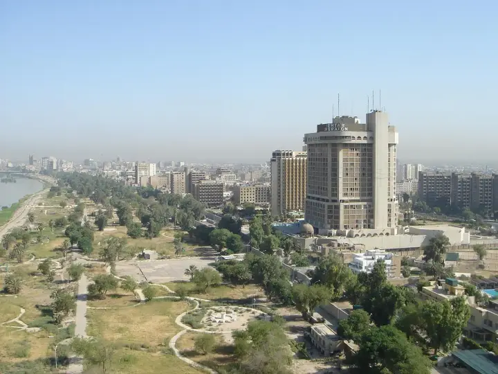 Bagdad, ojczyzna Sindbada Żeglarza, z hotelem Ishtar Sheraton i zielonymi terenami nad rzeką.