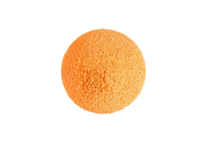 Une balle de nettoyage orange, texturée et spongieuse, prête à faire briller votre maison.