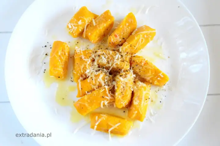 Pyszne kopytka z dyni, polane masłem i posypane parmezanem, tworzą jesienną ucztę.