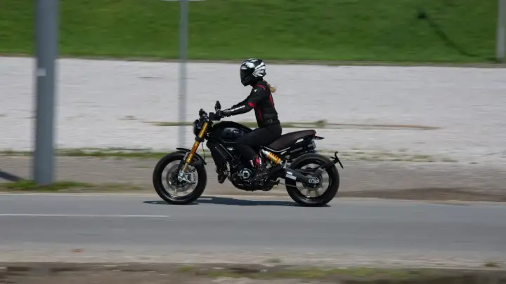 Kobieta w kasku i kombinezonie jedzie motocyklem spełniającym normę **euro 4**.