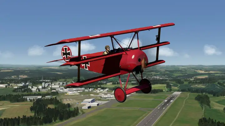 Ein rotes Fokker-Flugzeug mit Eisernem Kreuz fliegt über eine grüne Landschaft mit einer Stadt und einem Flugfeld.