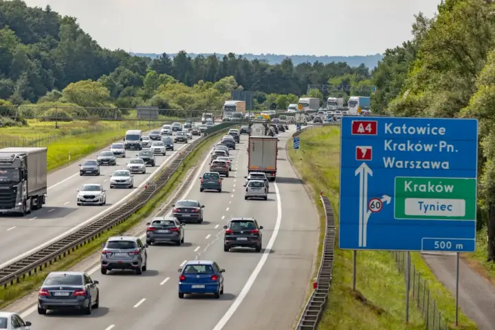 Korek na autostradzie A4 w kierunku Katowic. Samochody stoją w długim sznurze, a znaki drogowe wskazują drogę do Krakowa i Tynca.