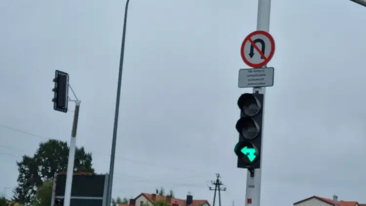 Sygnalizacja świetlna z zieloną strzałką w lewo i znakiem "zakaz zawracania", który nie dotyczy samochodów osobowych i jednośladów.