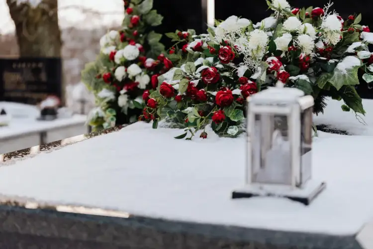 Wieniec z czerwonych róż i białych chryzantem na śniegu. Pamięć o tych, co odeszli.